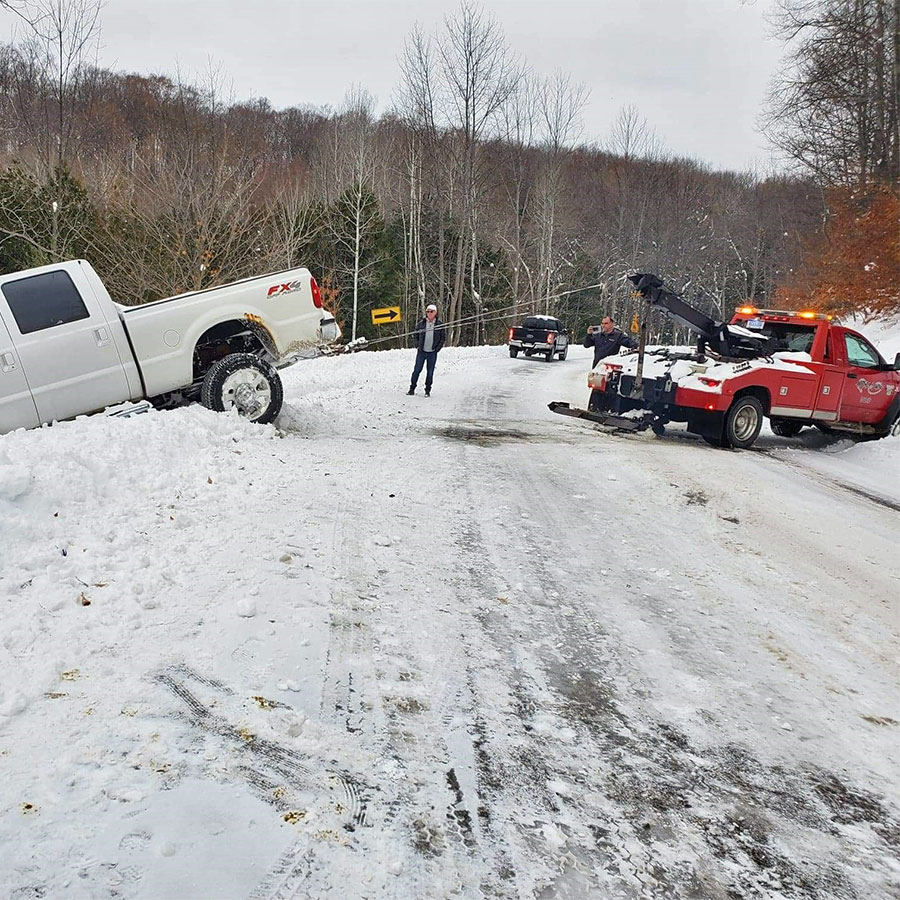 Anytime towing wrecker winching a vehicle out of the ditch 